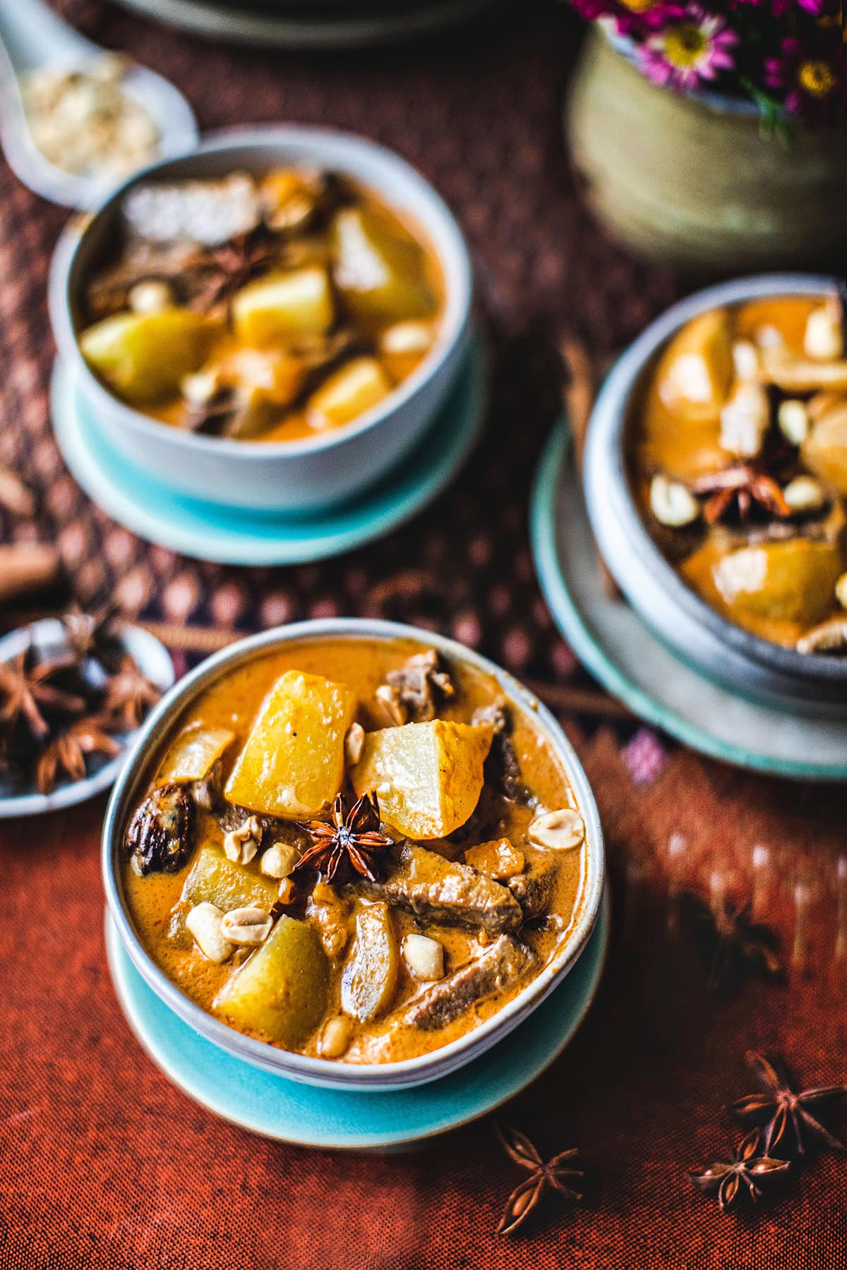 Thai beef massaman curry in 3 bowls on a table. 