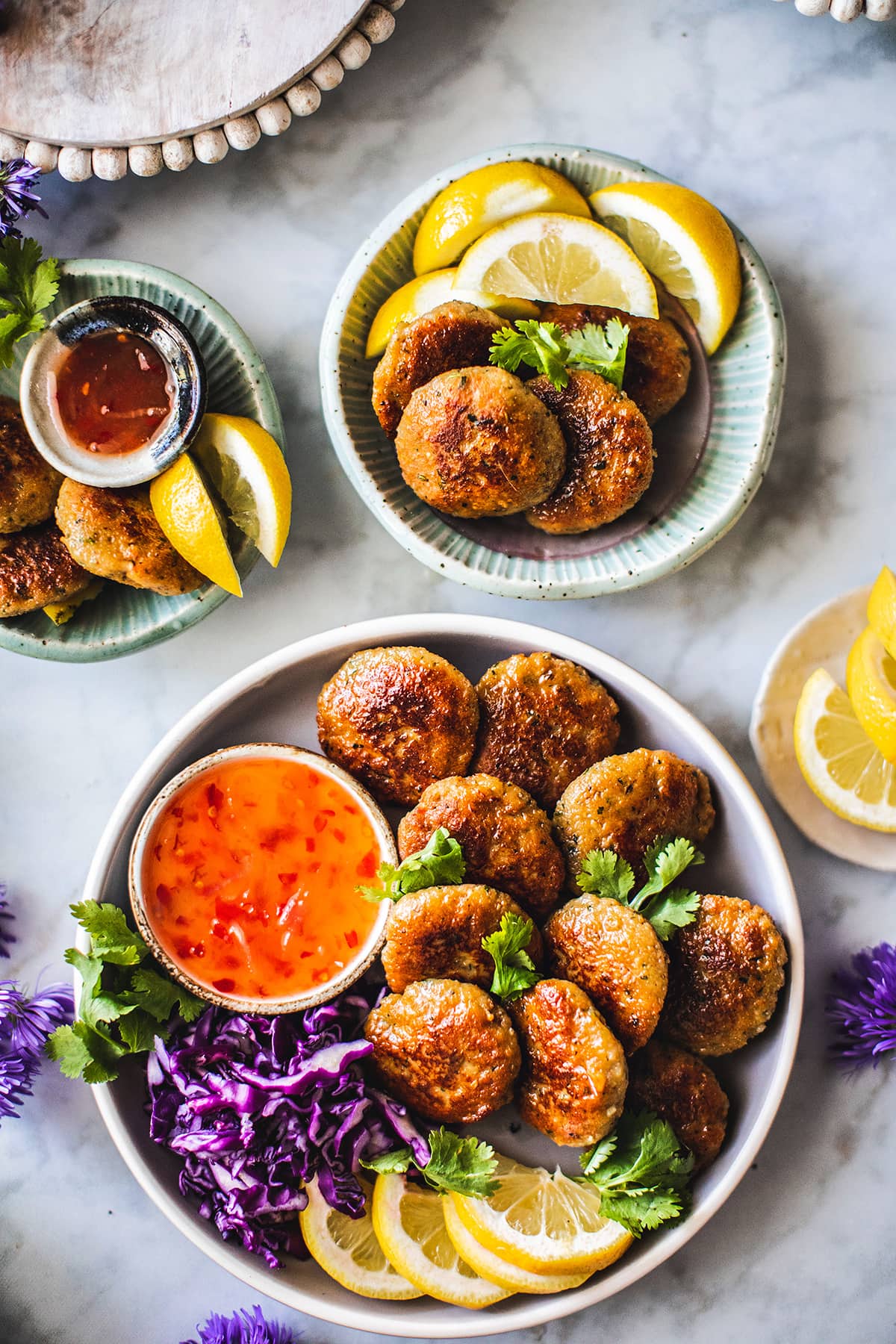 Thai shrimp cakes on platters with chili sauce on the side.