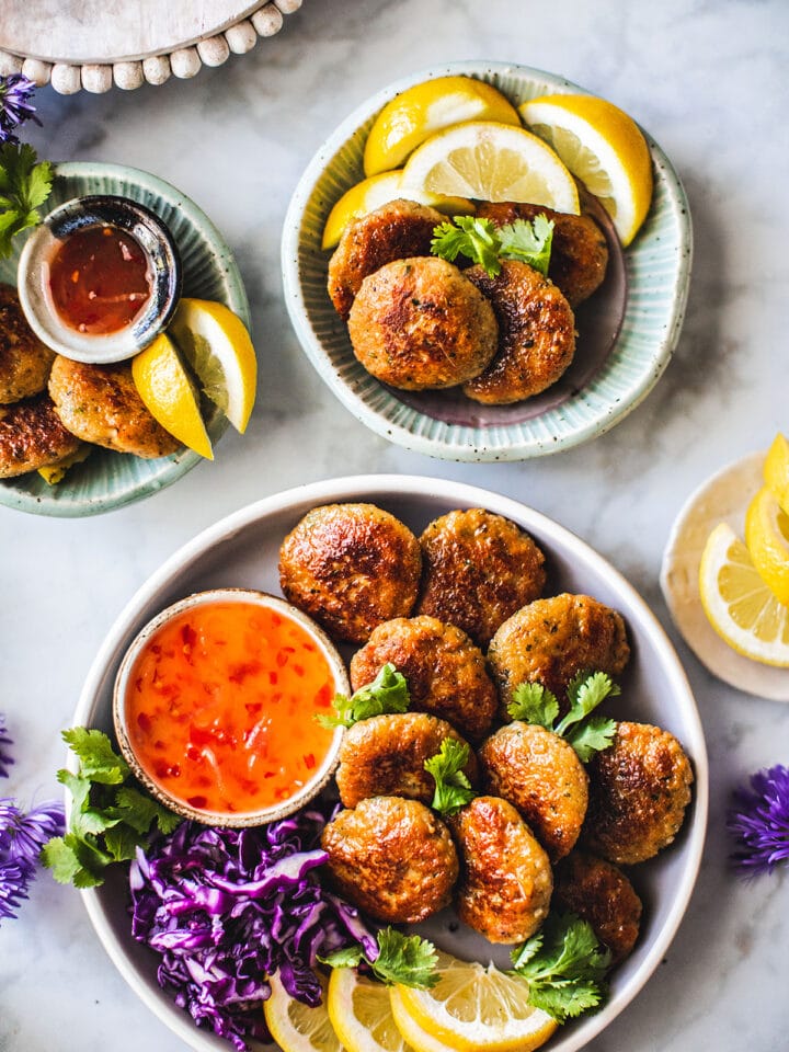 Shrimp cakes on a platter with dipping sauce on the side