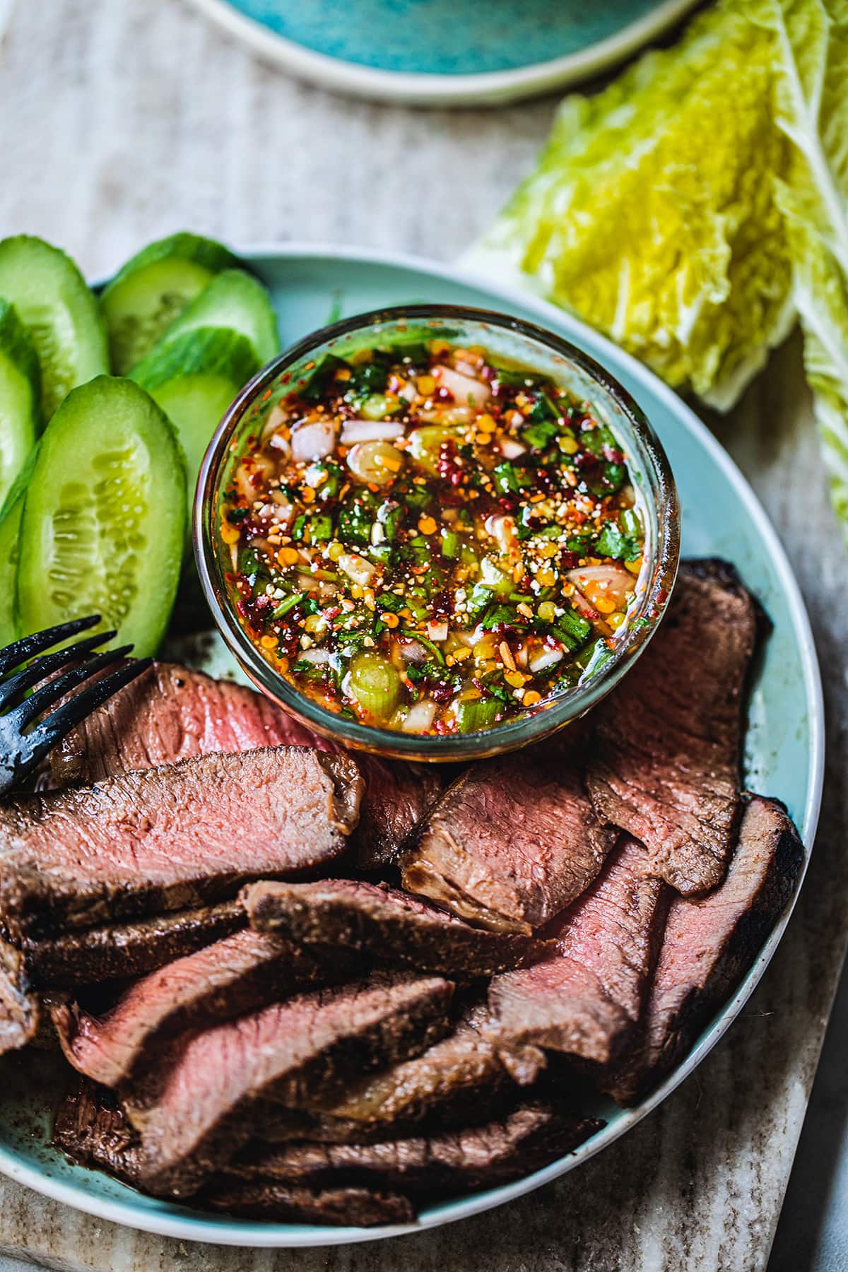 Nam Jim Sauce on a plate with sliced steak.