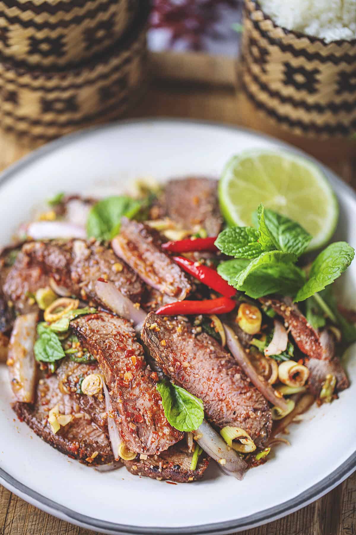 Nam Tok beef waterfall salad on a plate with herbs.