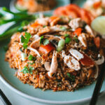 A plate of tom yum fried rice with turkey meat.