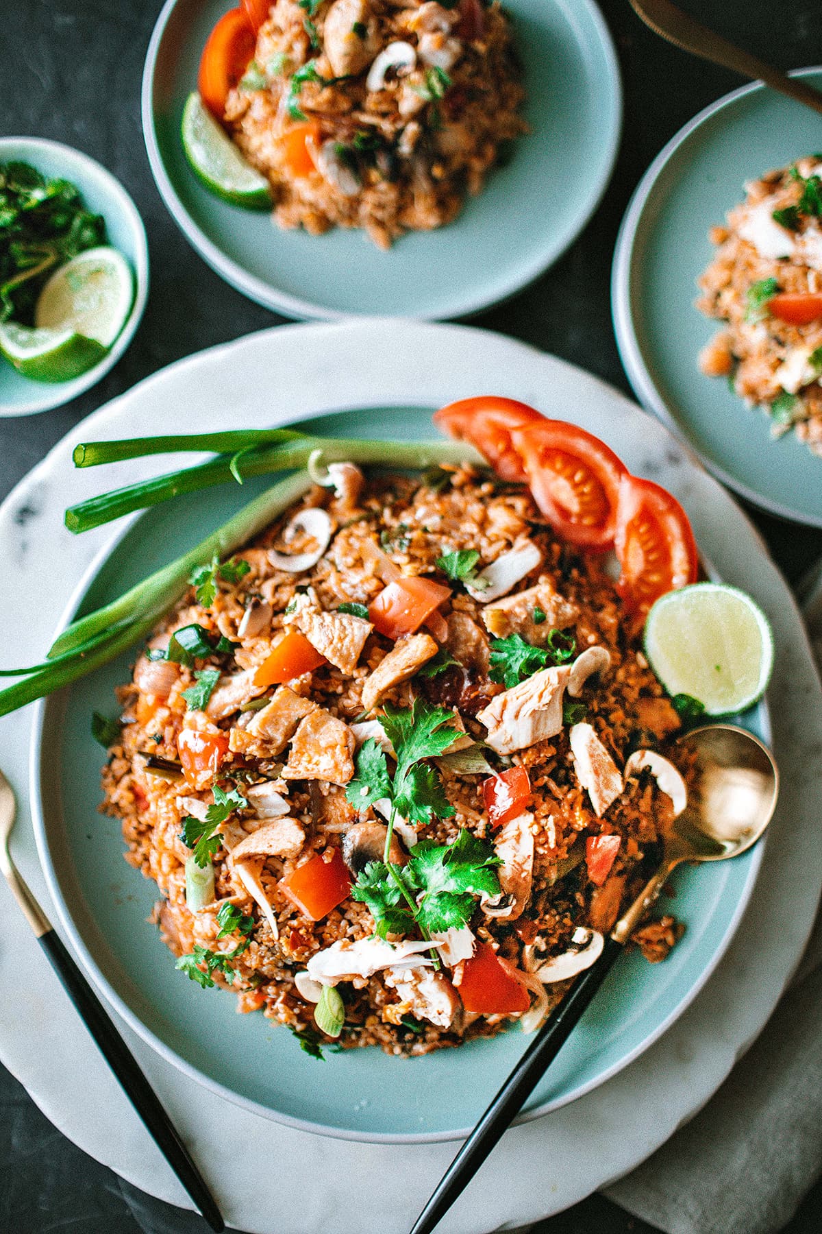 Chicken Tom Yum fried rice on a plate with garnishes.