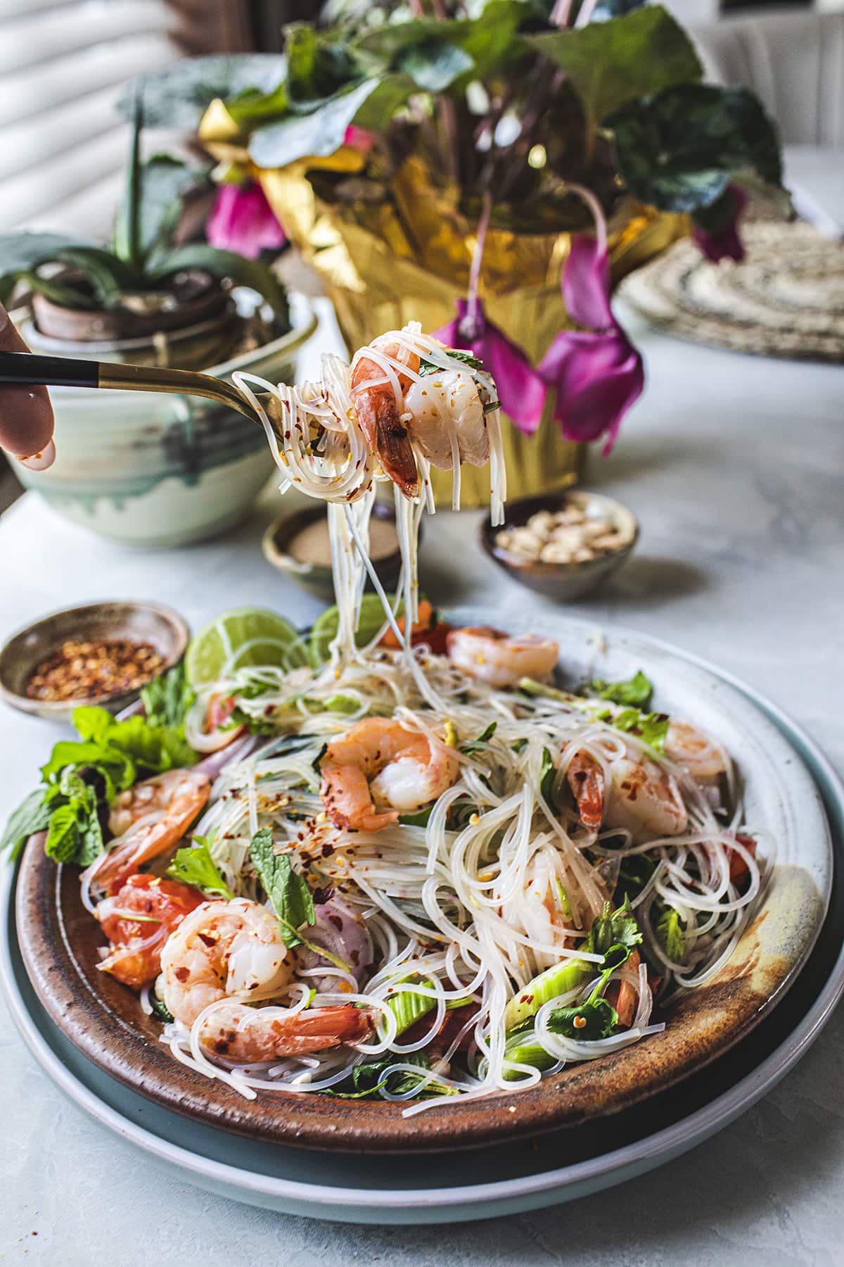 fork lifting a bite of glass noodles salad.