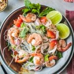 Glass noodles salad with shrimp on a platter with lime slices for garnish