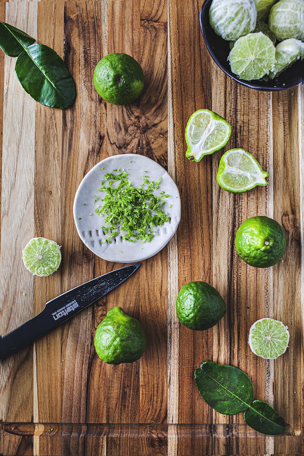 Kaffir limes and shaved rind on a cutting board