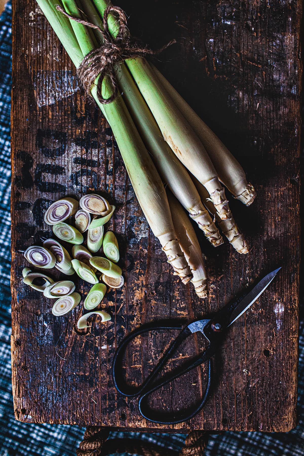 chopped and stalks of lemongrass and a scissor on a wooden box