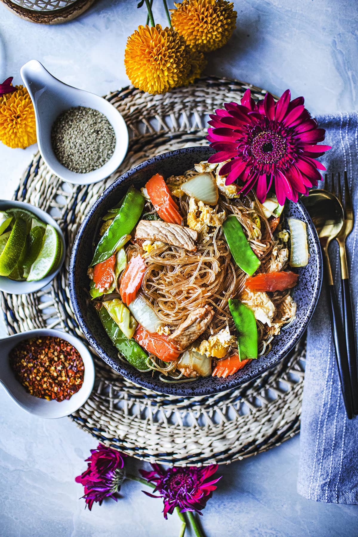 glass noodles stir fry or Pad Woon Sen on a plate with garnishes on the side. 