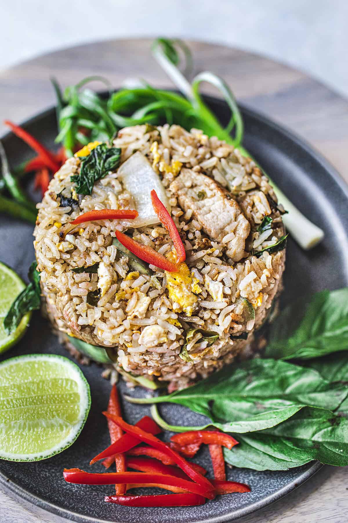 Green curry fried rice on a plate with garnishes.