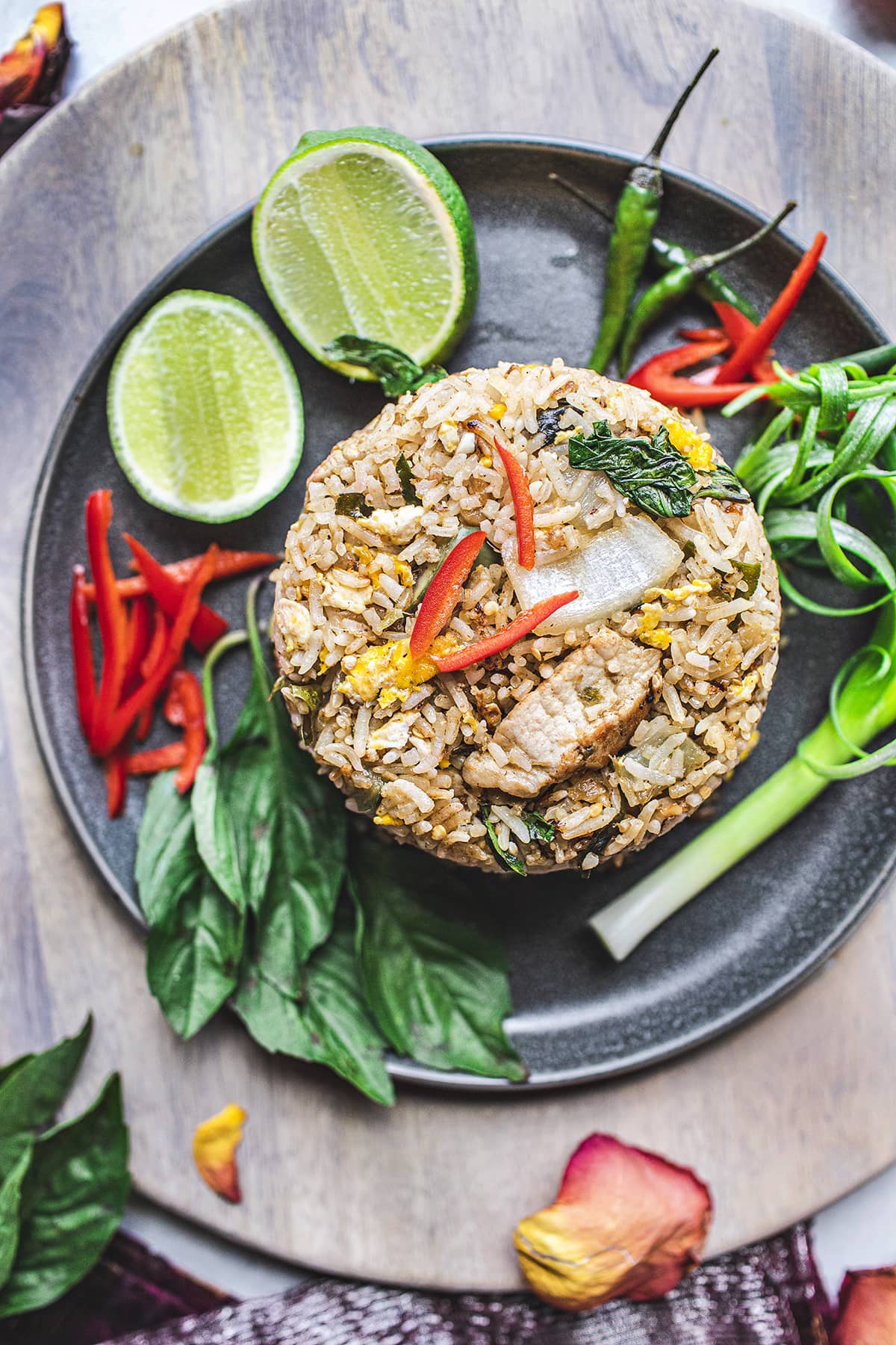 green curry fried rice on a black plate with herbs garnishing.