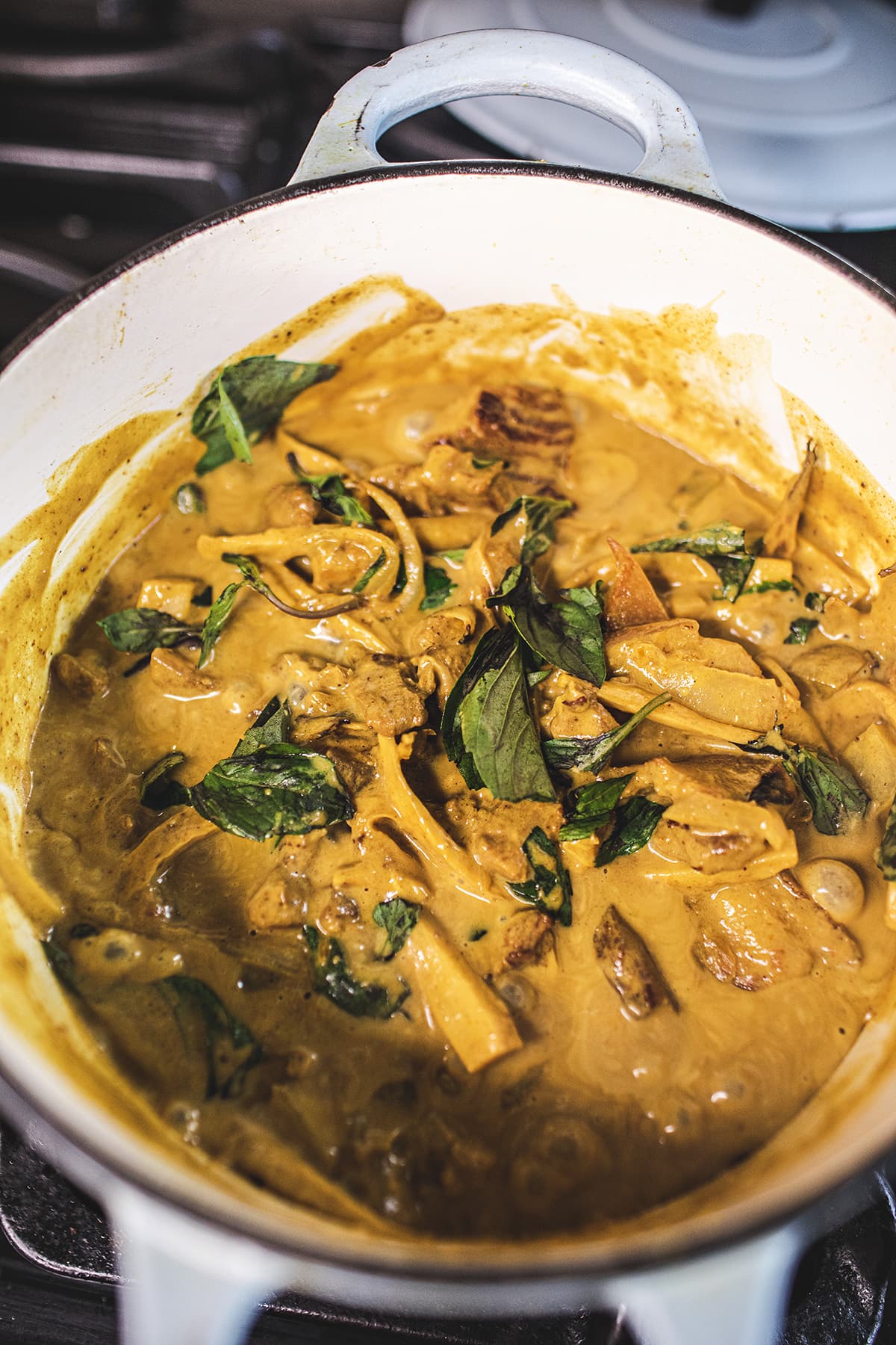 thai yellow curry with pork belly in a soup pot on the stove