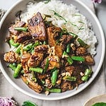 pork stir fried over rice in a plate