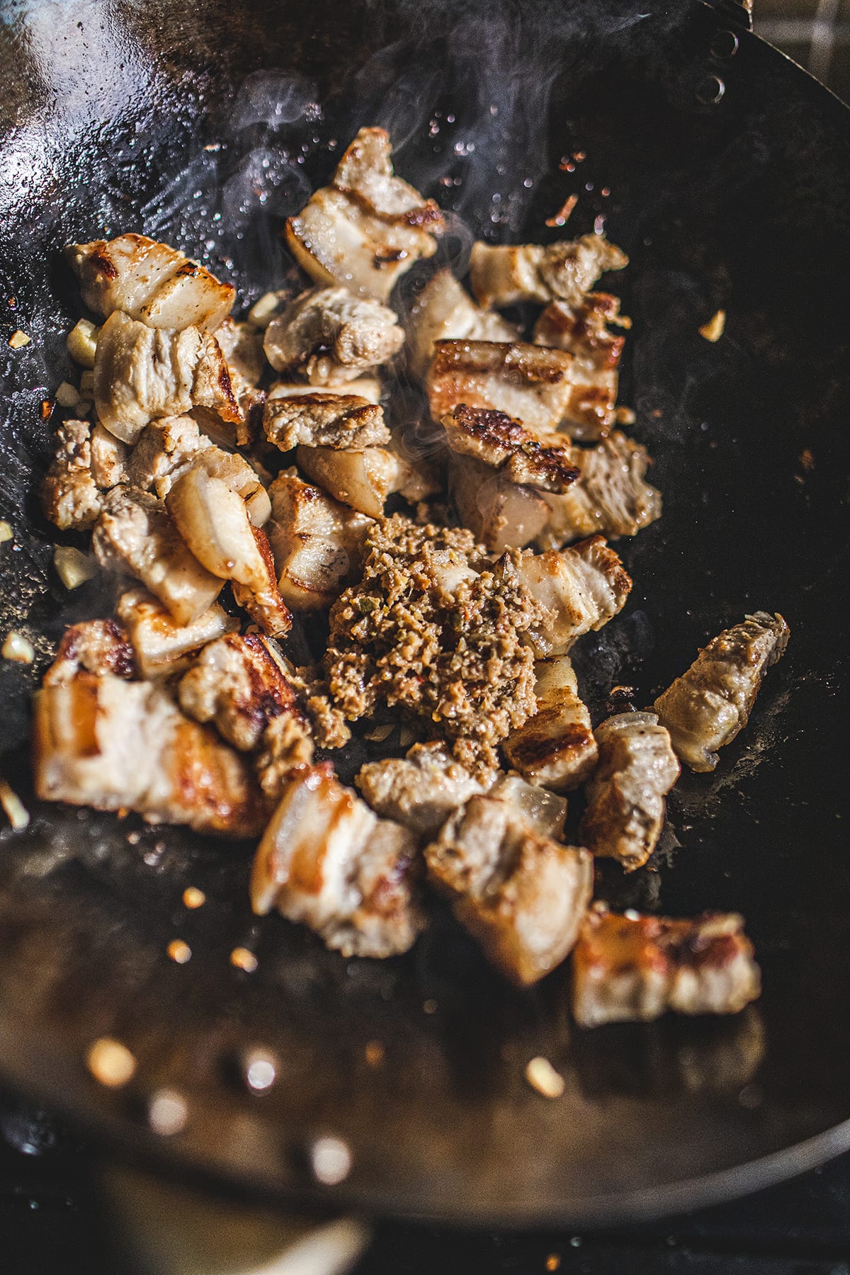 Thai pork belly and prik Khing paste frying in a wok.