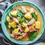 pineapple curry in a green bowl with basil garnish