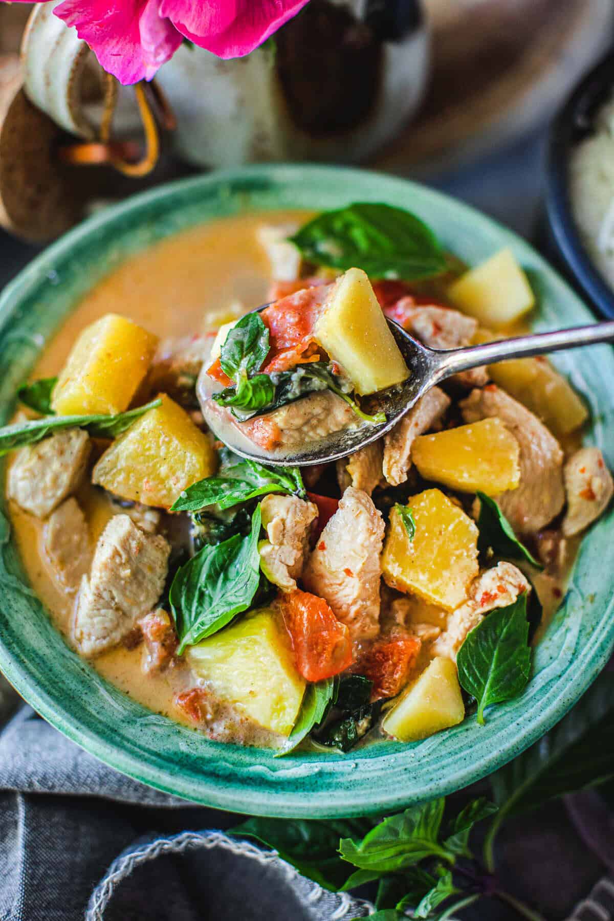 a spoonful of pineapple curry over a bowl of curry