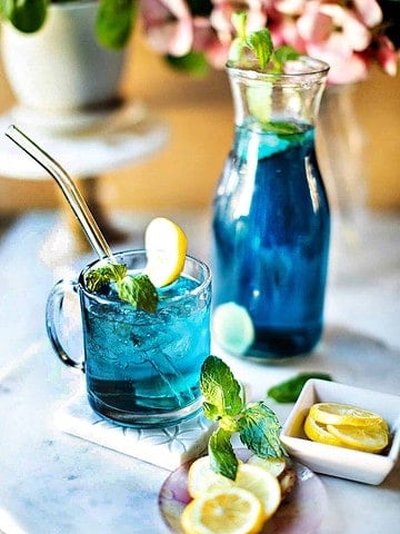 Thai butterfly blue tea in a glass with pitcher.