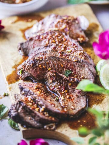 sliced beef with chili sauce over it