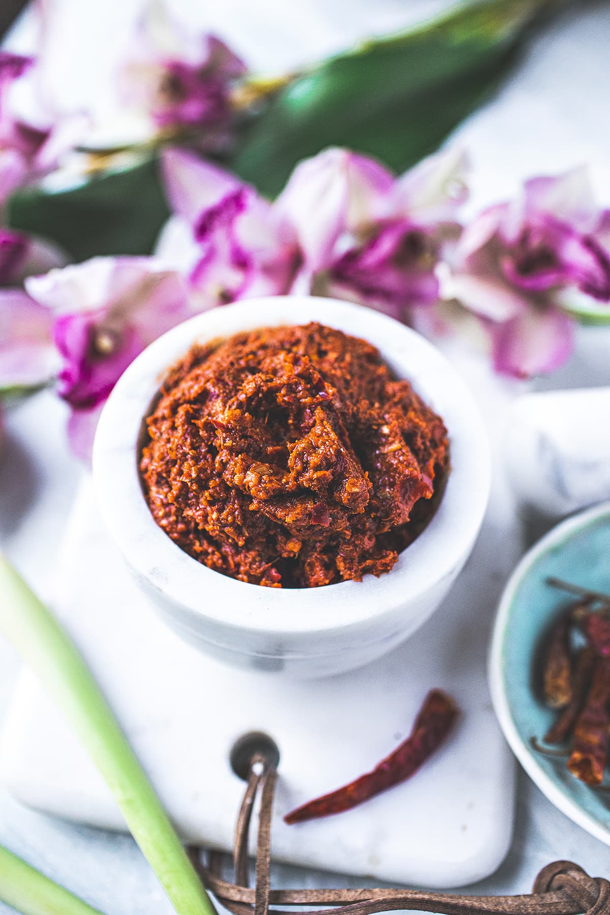 red curry paste in a white bowl over cutting board