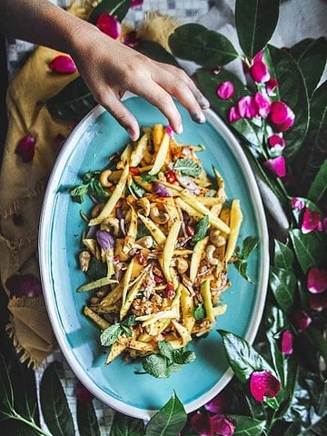 Hand reaching for mango salad