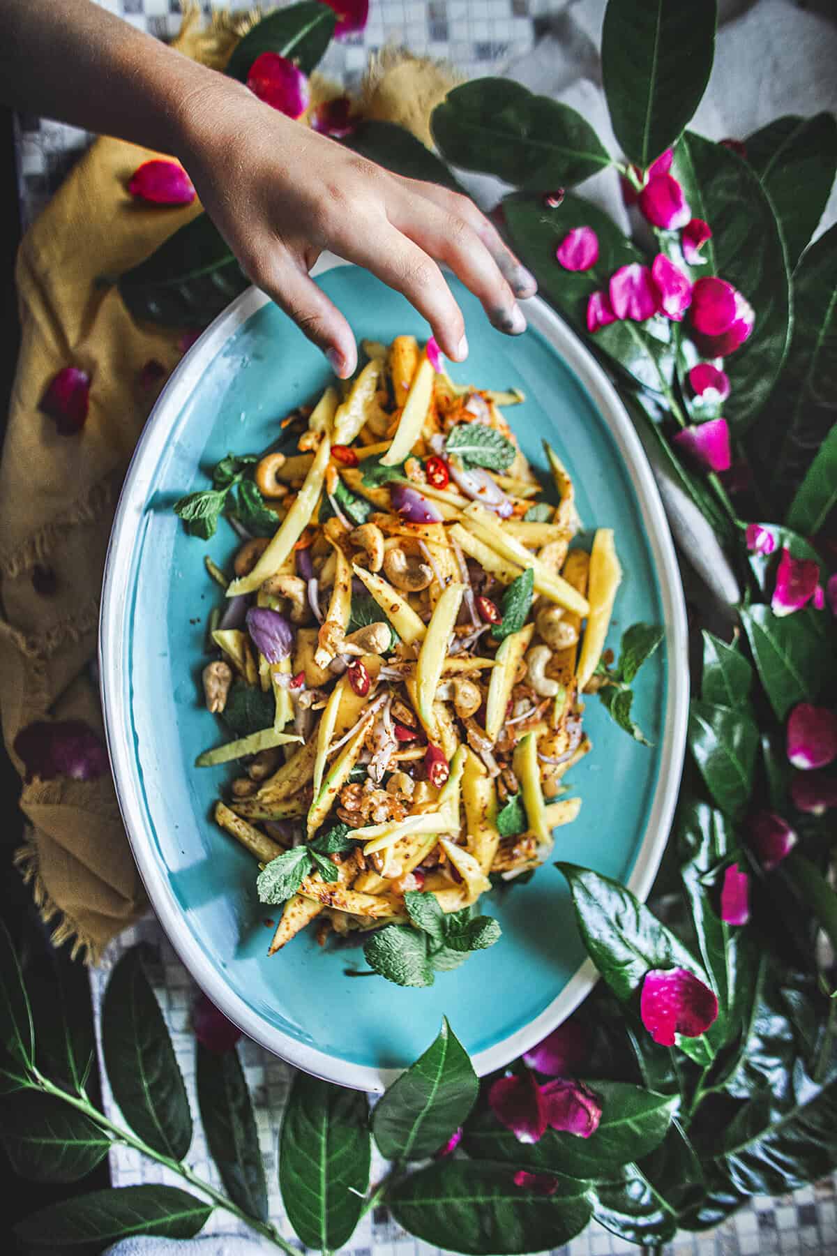 Hand reaching for mango salad