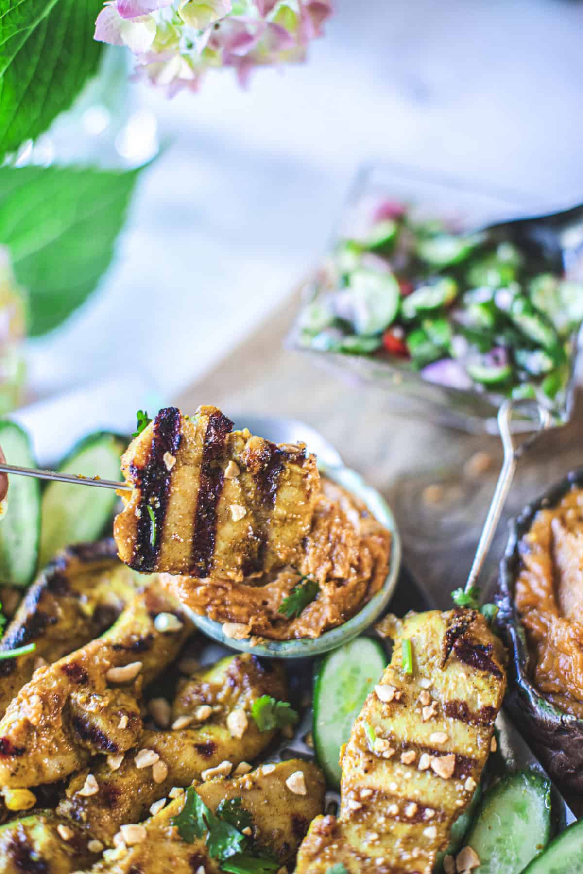 skewers dipped in peanut sauce