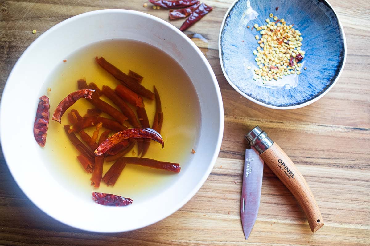 Dried red chilis soaking in a bowl.