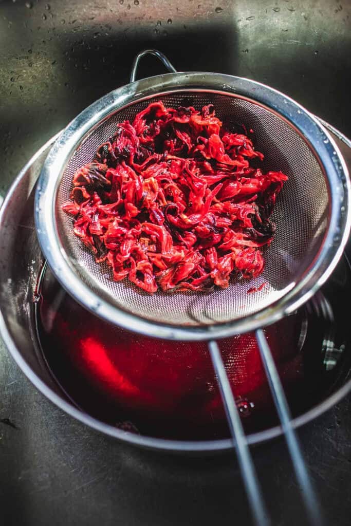 straining Thai hibiscus tea flowers.