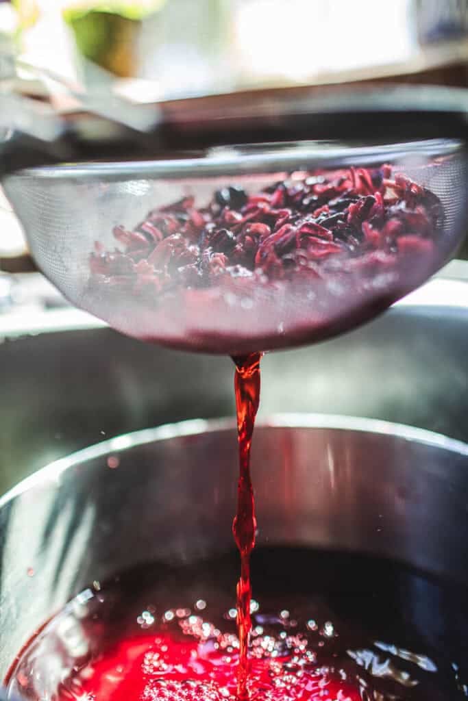 straining hibiscus tea flowers