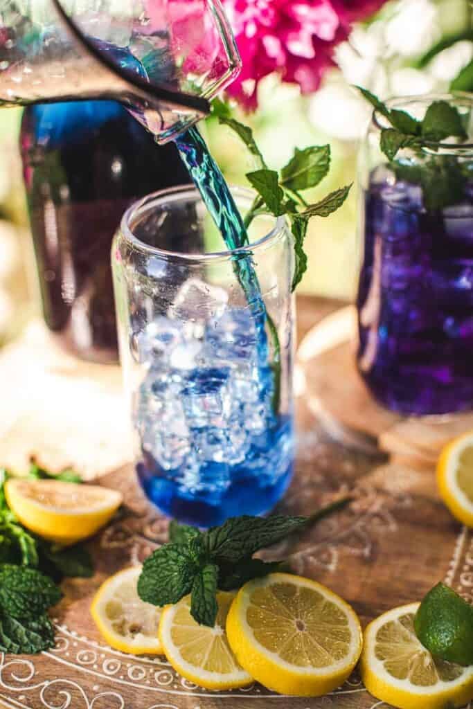 blue tea poured over a glass of ice