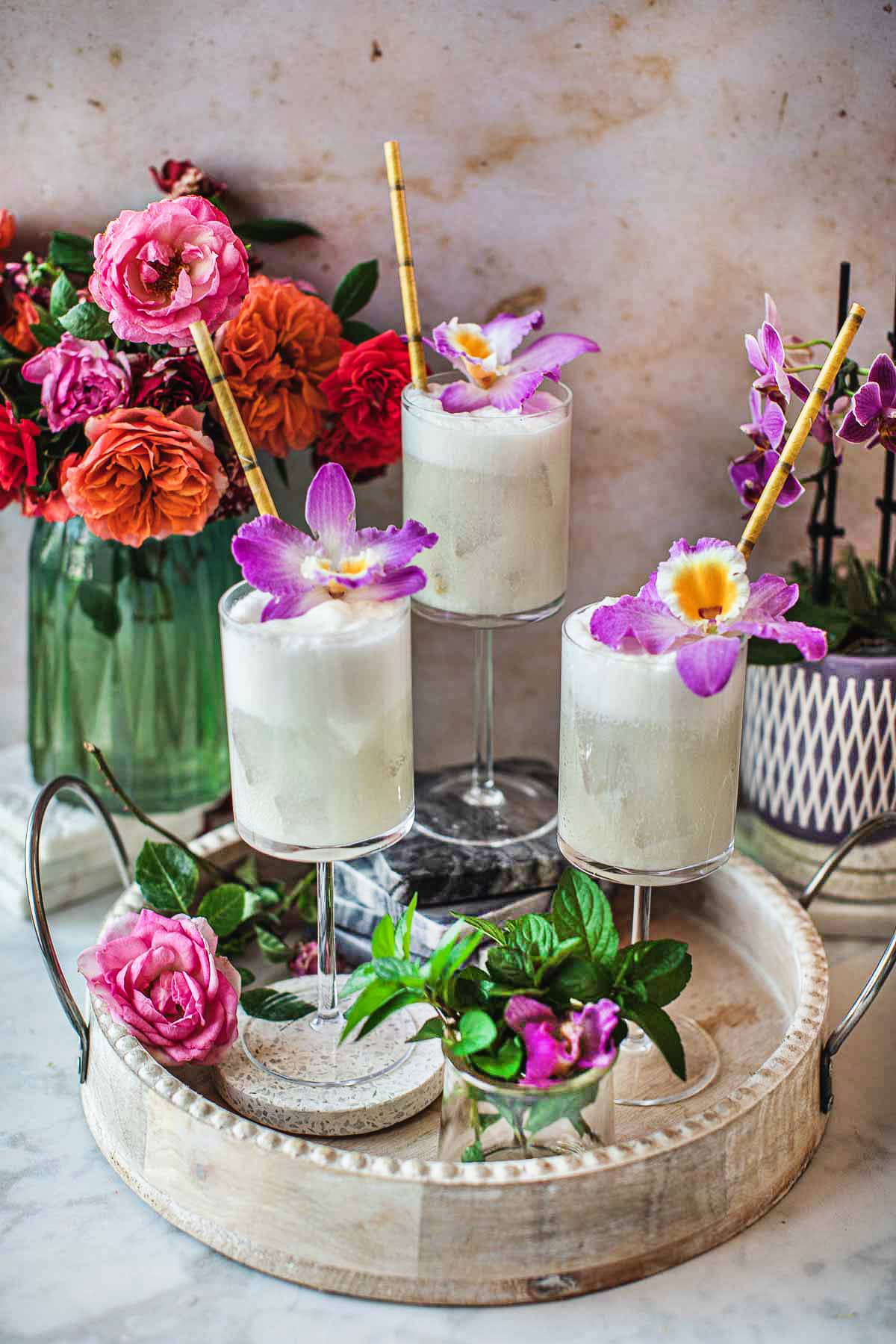 3 glass of coconut mojito on drink tray with herbs.