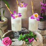 Creamy coconut lime mojito in 3 glasses on a tray.