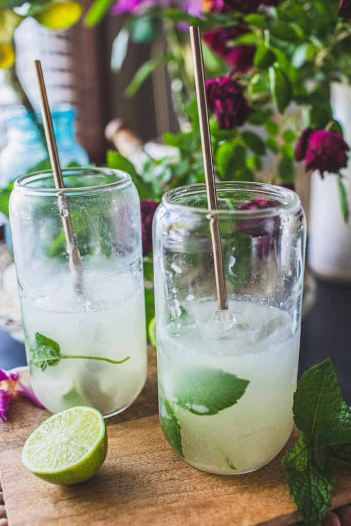 2 glassed coconut mojito mojitos with ice and herbs.