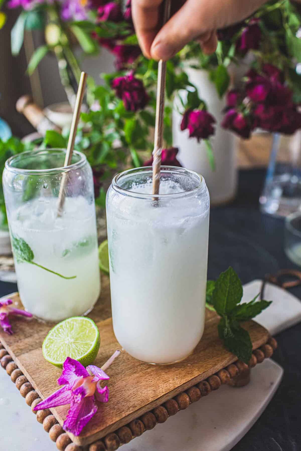 2 glasses of coconut mojito on a tray on the table. 