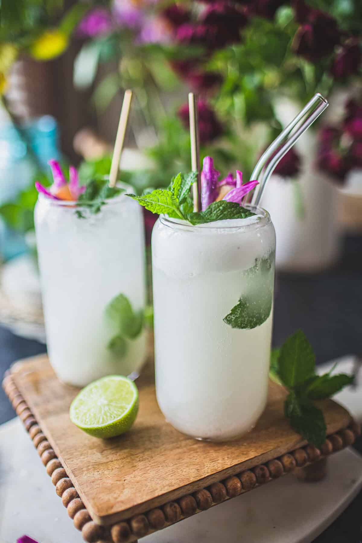 2 glasses of mojito on a cutting board.