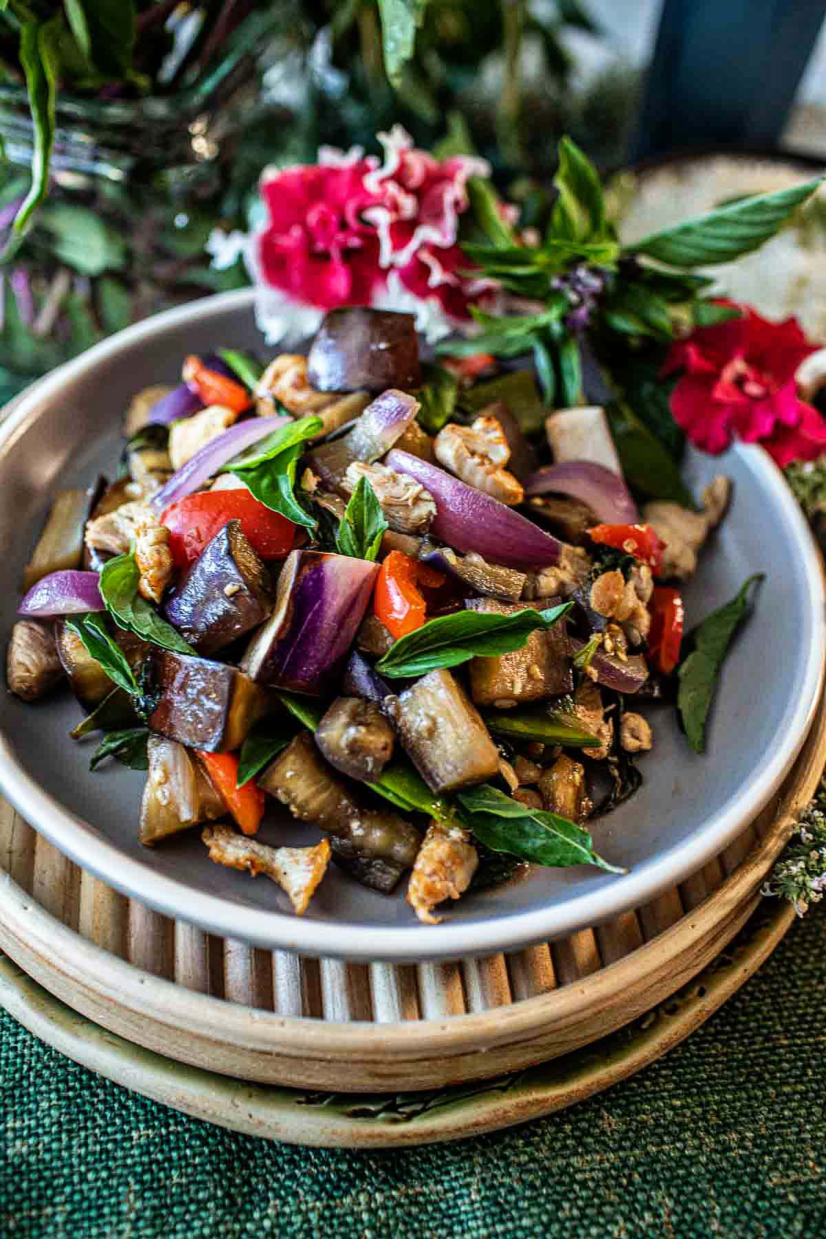 eggplant stir fry on a plate with flowers decor