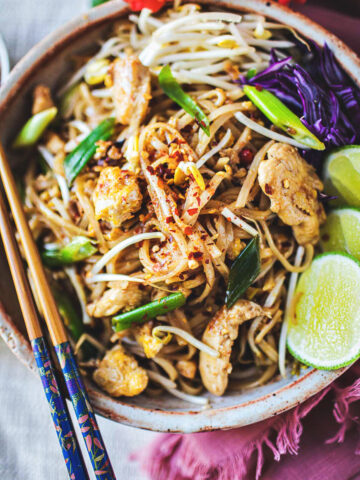 pad mee korat stirfry in a bowl with lime garnish