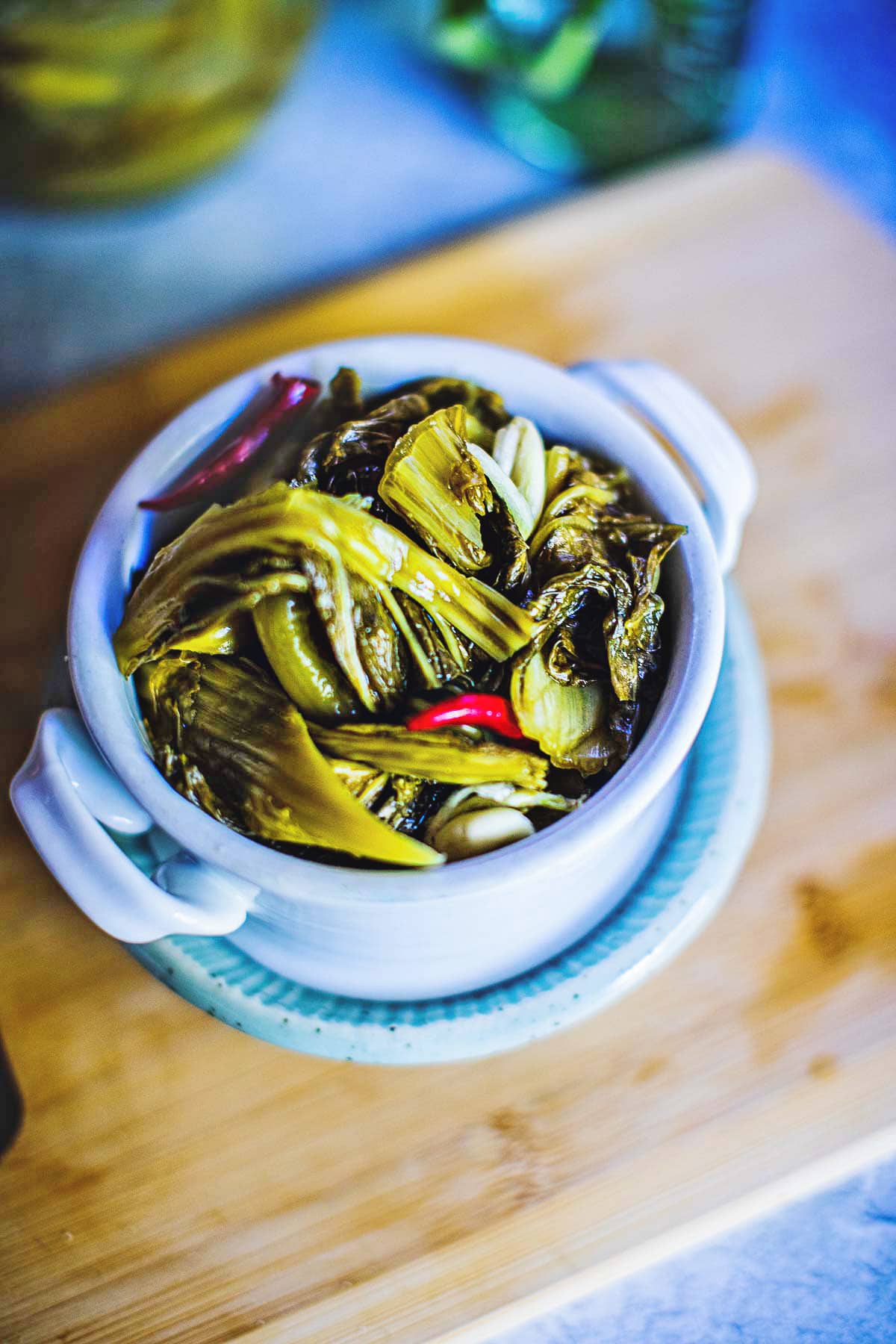 pickled mustard greens in a white cup