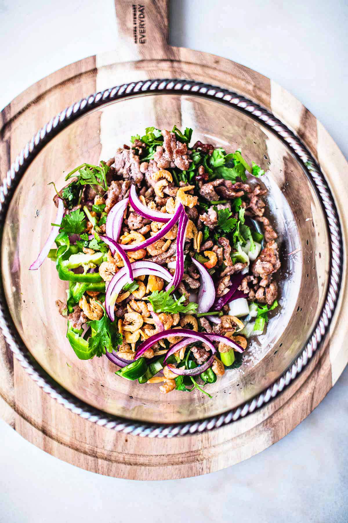 salad in a glass bowl over cutting board