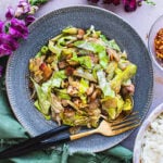 Stir fried cabbage on a plate with fork and spoon