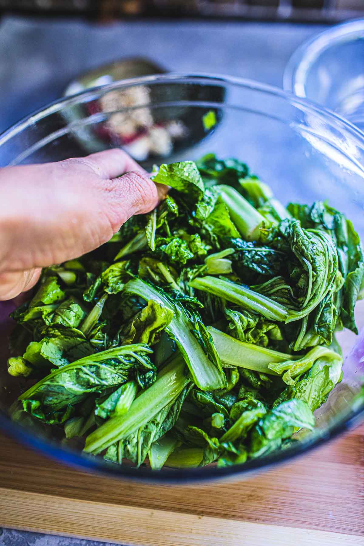 hand massaging mustard greens