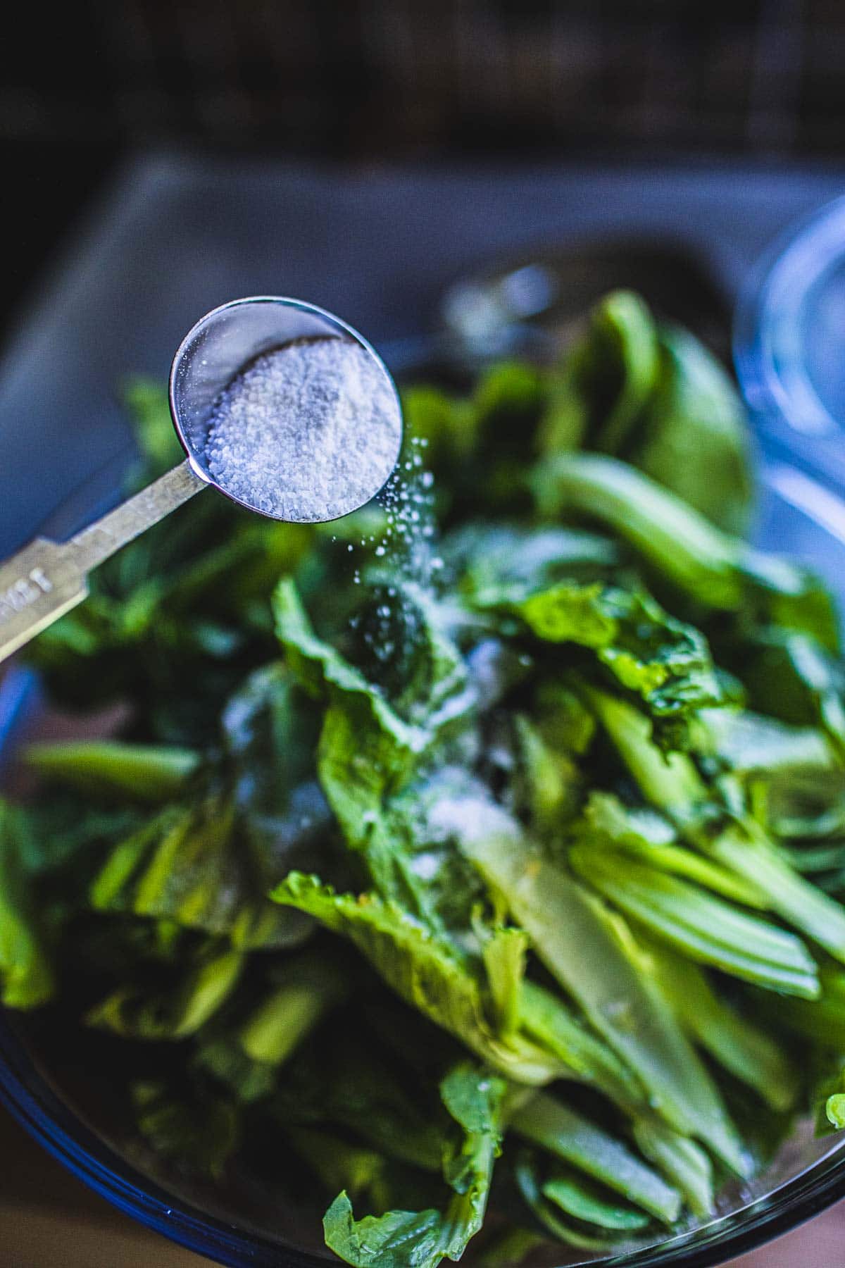 pouring salt over mustard greens