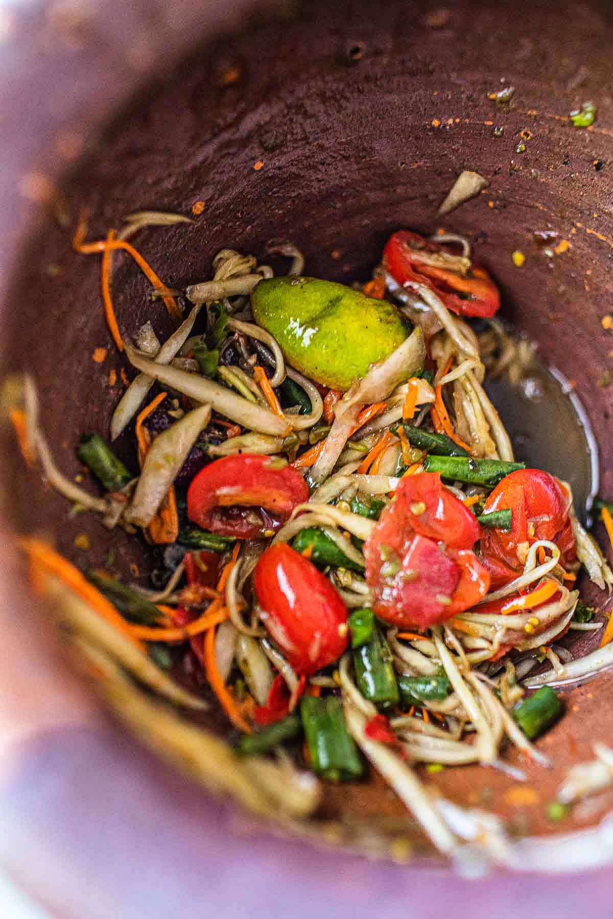 lao tum som salad in a mortar