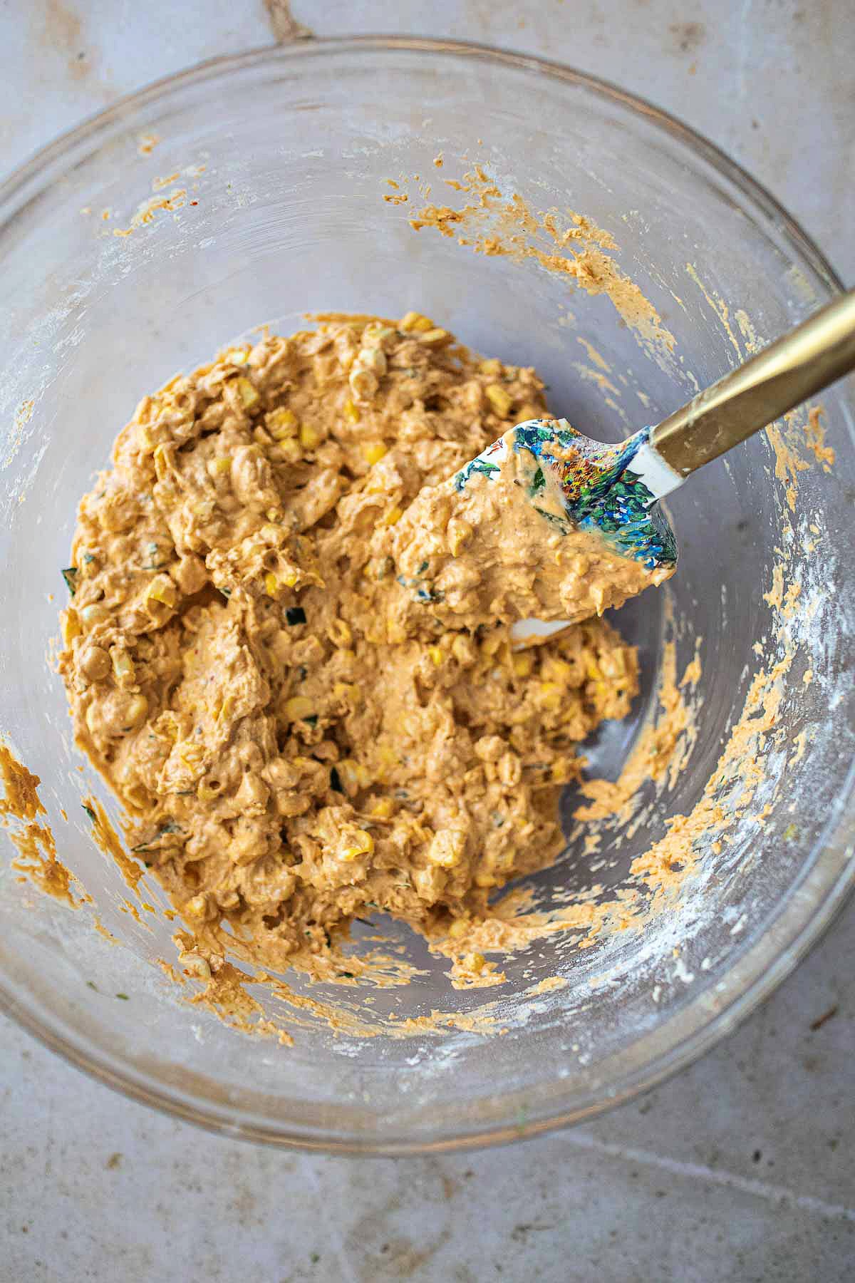 corn fritter batter in a glass bowl with spatula