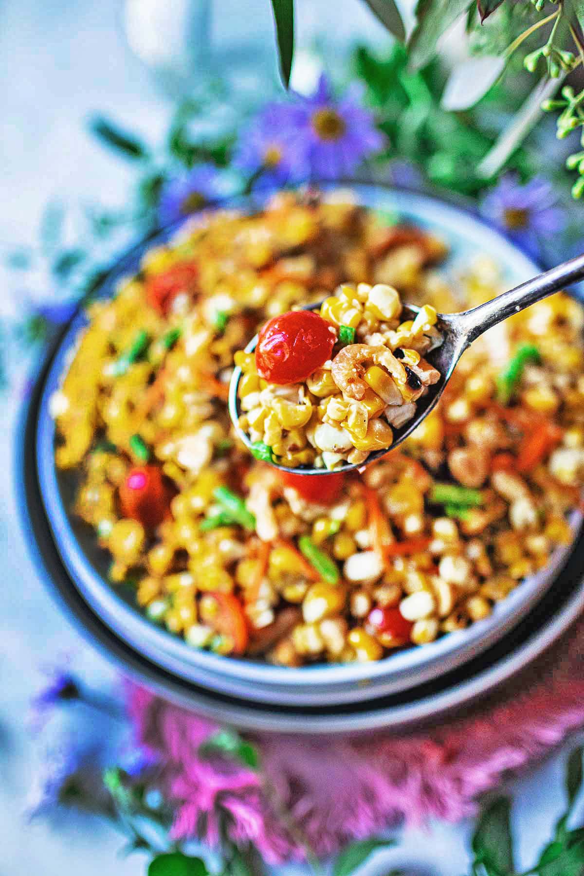 spoon lifting thai grilled corn salad from a bowl