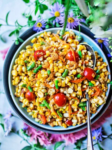 thai corn salad in a bowl with flowers on table