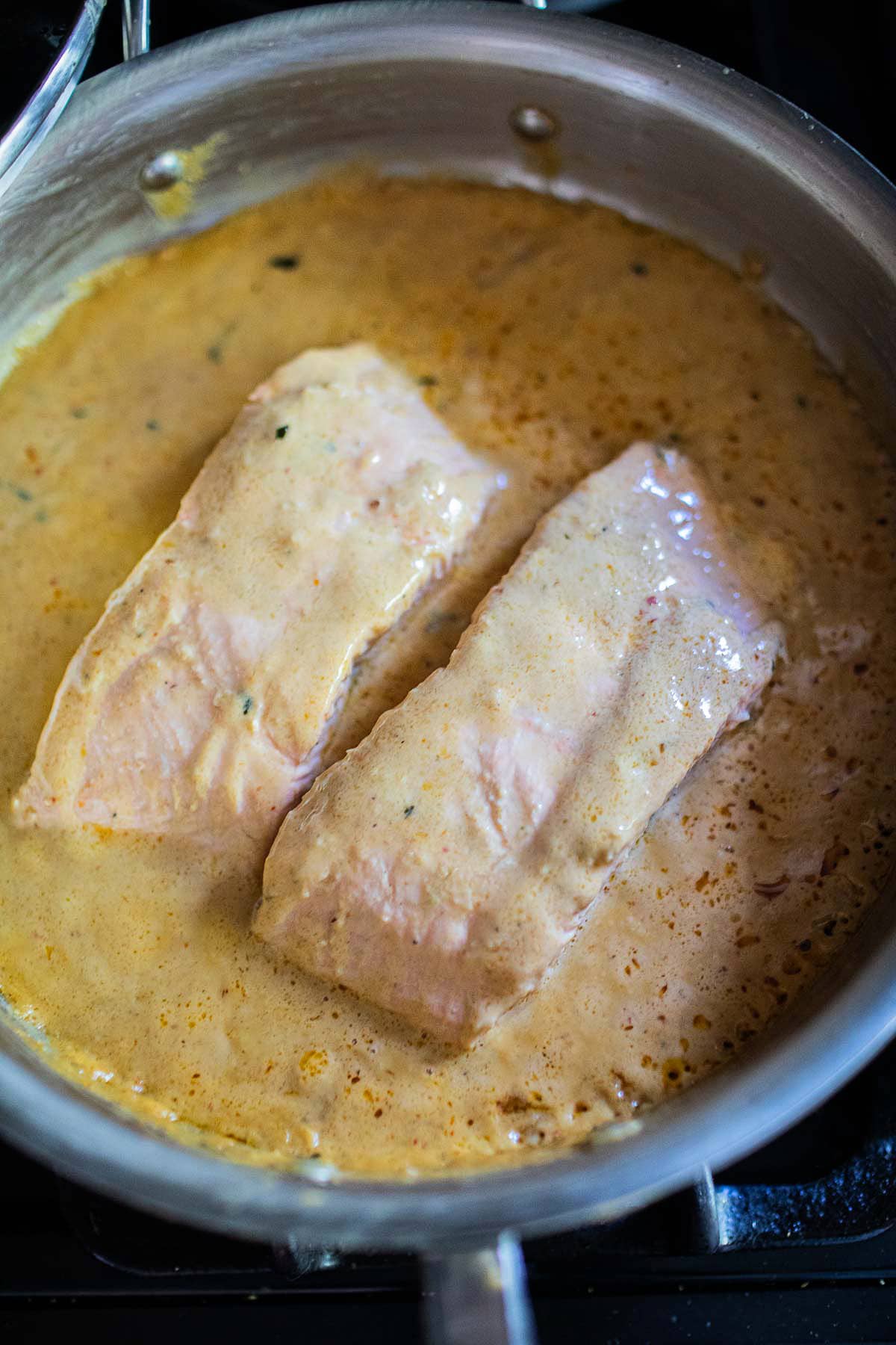 choo chee salmon fillets in a curry sauce in a pan
