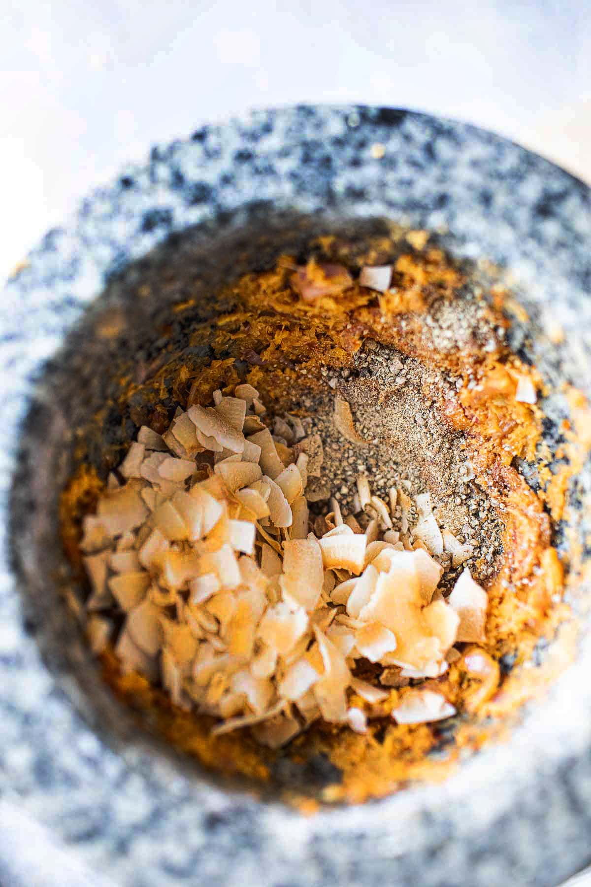 toasted coconut flakes in a stone mortar