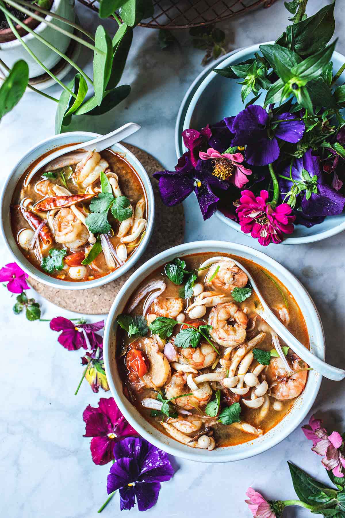 two bowls of tom yum soups on the table 