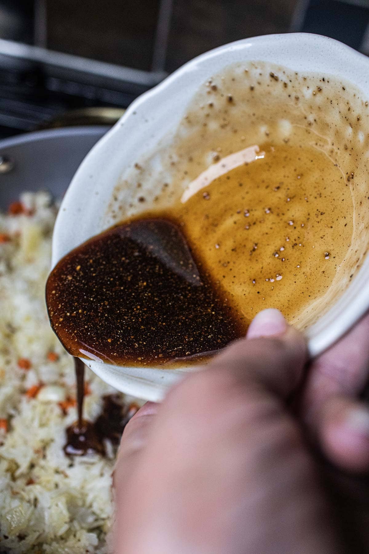 fried rice sauce pouring into a pan