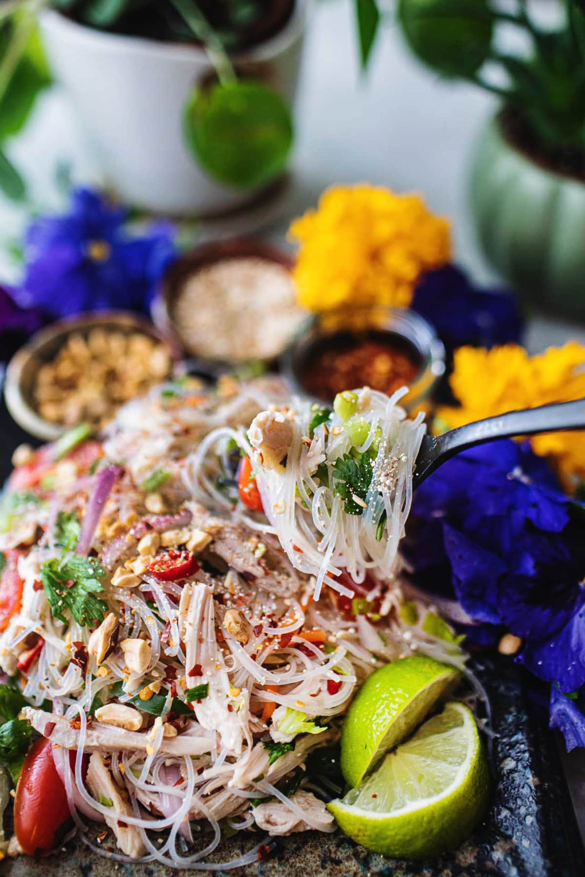 fork lifting glass noodles salad from a plate